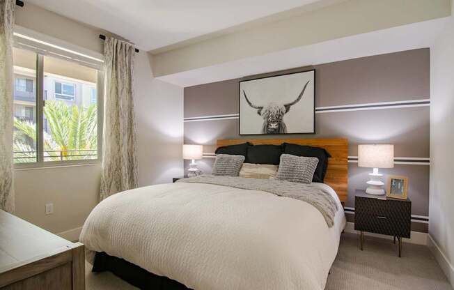 A bedroom with a large bed and a painting above it.