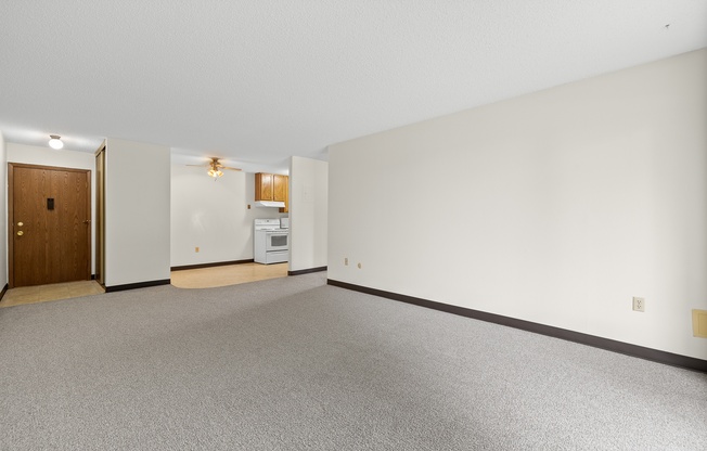 A room with a carpeted floor and a wooden door.