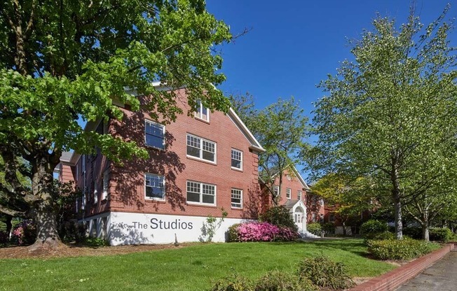 a large brick building with a sign that reads the studios at MILEPOST 5 Apartments, PORTLAND, 97213
