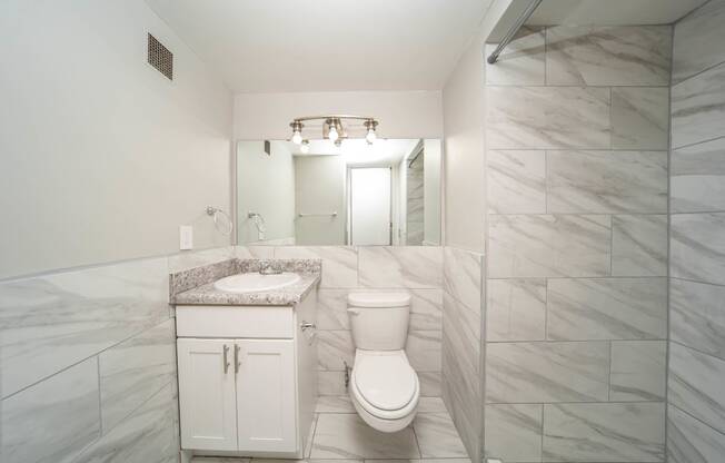 a bathroom with a toilet and a sink and a shower