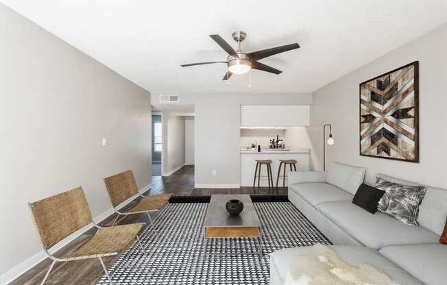 Model Living Room with Wood-Style Flooring and Kitchen View at Indigo Park Apartments in Albuquerque, NM.