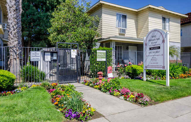 a home with a sign and flowers in front of it