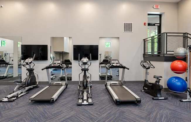 Fitness center with treadmills, stationary bikes and exercise balls at Icon Avondale Apartments in Decatur, GA.