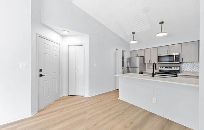 A kitchen with white cabinets and a white countertop.