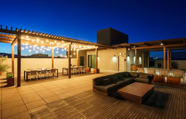 A patio with a couch, chairs, and string lights.