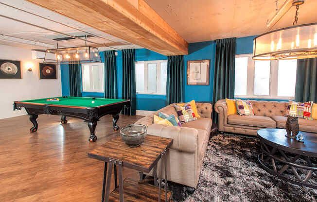 A room with a pool table and a couch.