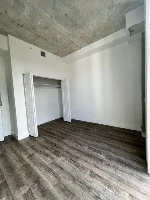 an empty room with white walls and wooden floors