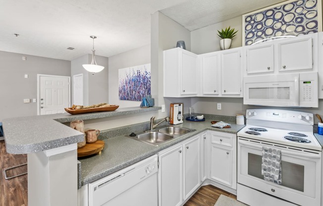 A kitchen with white cabinets and appliances.