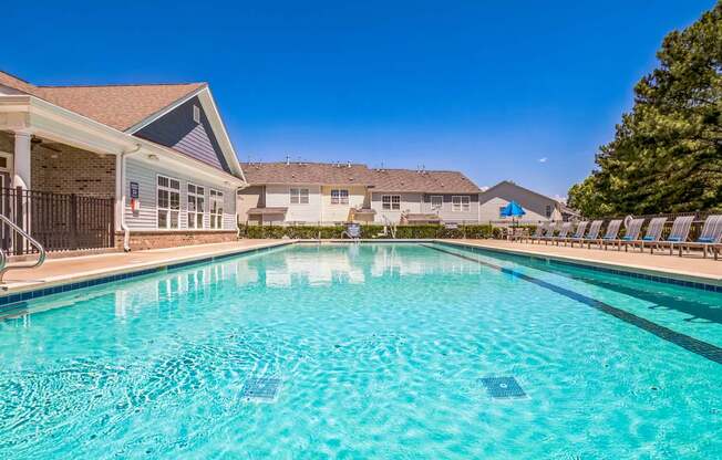 A swimming pool in a residential area with houses in the background.