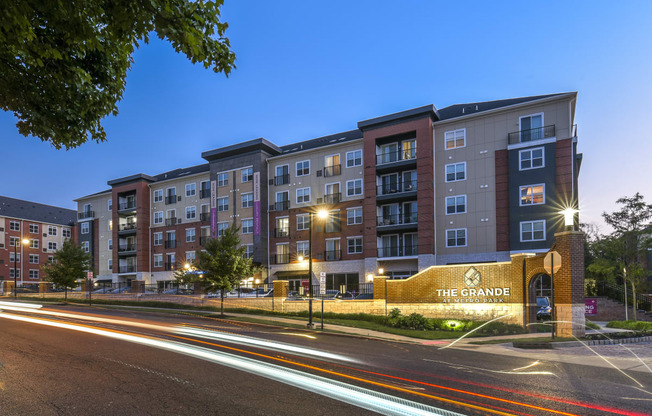 a city street with an apartment building at night
