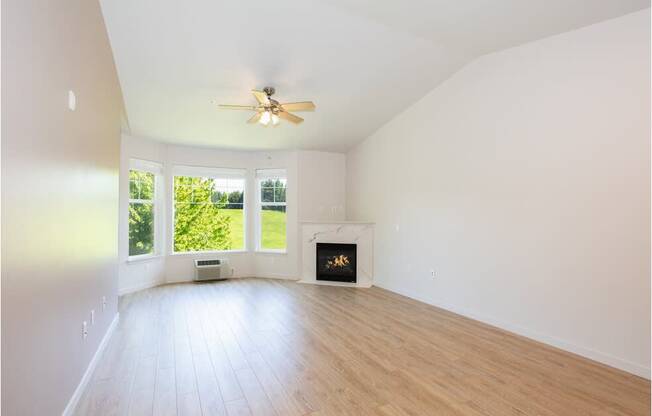 A room with a fireplace and a ceiling fan at Wilsonville Summit Apartments, Wilsonville , OR, 97070