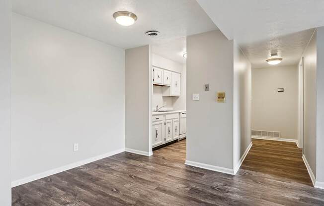 A kitchen with white cabinets and a wooden floor.