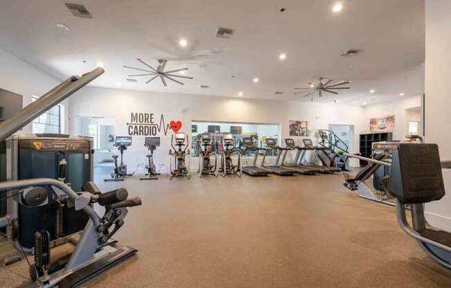 a spacious fitness center with cardio equipment and exercise machines