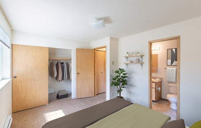 A room with a bed, a toilet, and a plant.