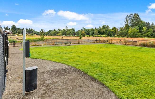 A grassy field with a fence and a signpost.
