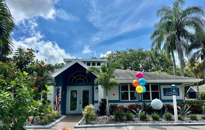a blue house with colorful balloons in front of it at Aqua Bay Apartments in Naples, FL 34116