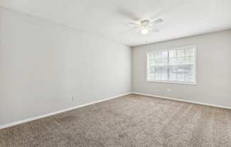 an empty room with carpet and a window