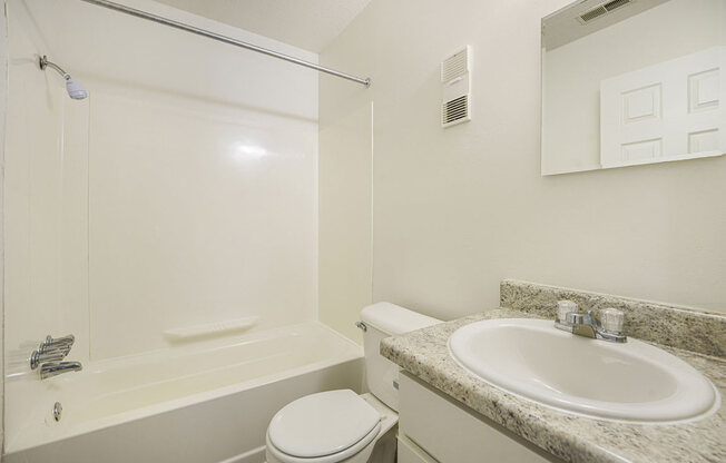 a bathroom with white cabinets at Newport Village Apartments, Portage, MI