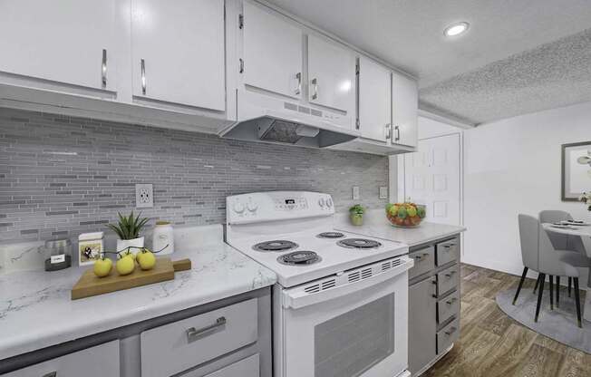 A modern kitchen with a white stove top oven and a wooden cutting board with lemons on it.