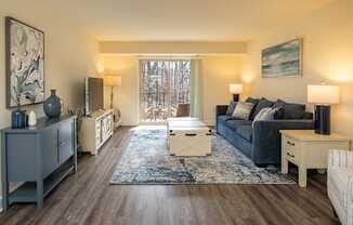 A living room with a grey sofa and a wooden floor.