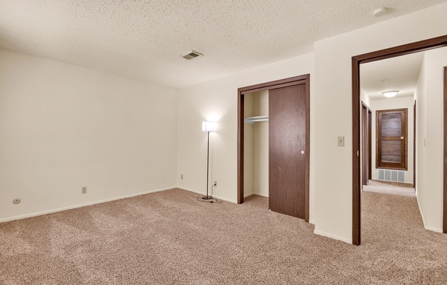 A room with a carpeted floor and a light on a stand.