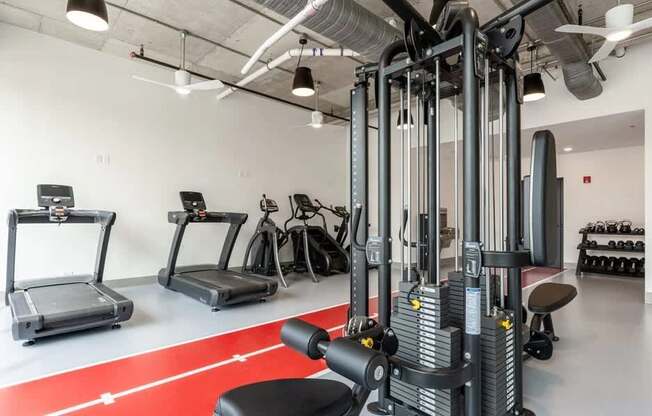 A gym with a red carpet and various exercise machines.