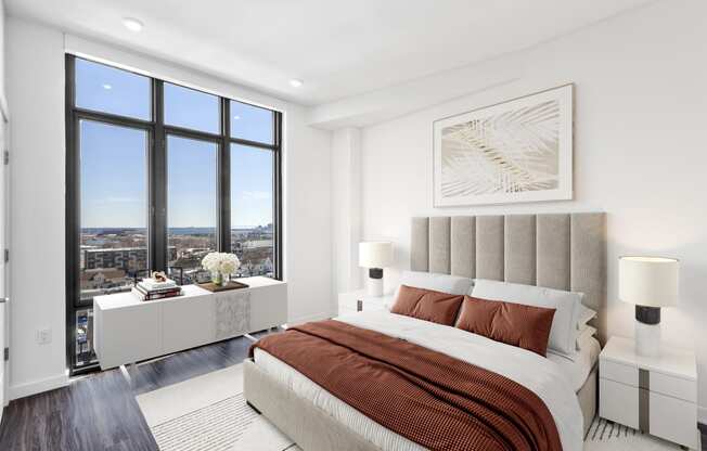 a bedroom with a bed and a large window