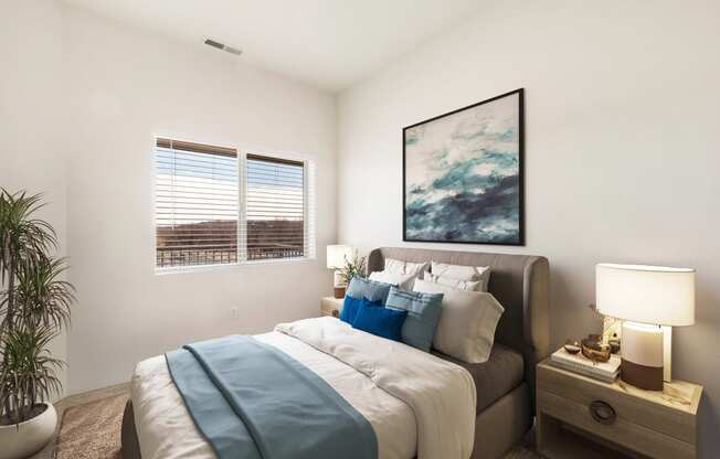 A large bedroom with carpet, white walls, a sunny window and a bed.at Shoreline Village, Richland