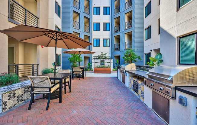 A patio with a table and chairs and an umbrella.