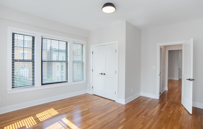 a living room with wood floors and a white door and window