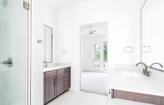 Primary bathroom showcasing one of multiple finish options, with a quartz vanity, wood-toned cabinetry, and a glass-enclosed shower tailored to your preferences.