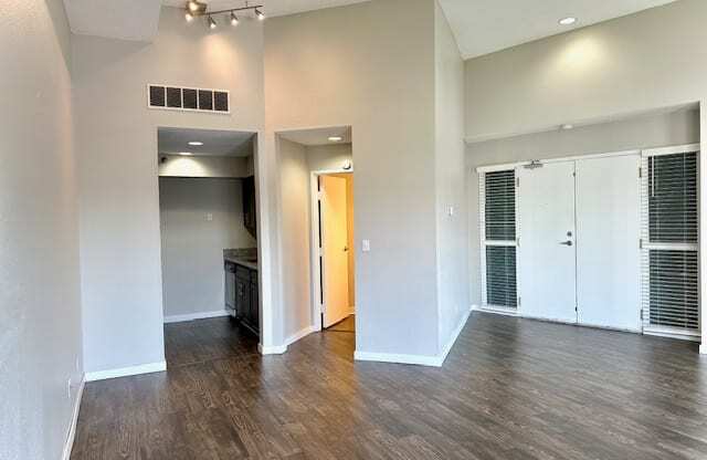 an empty living room with white walls and wood floors