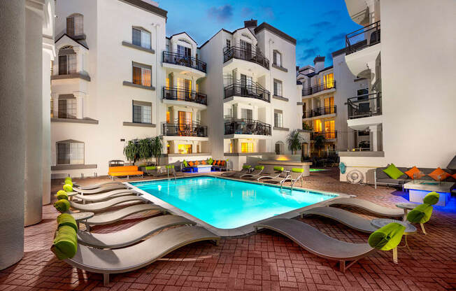 Apartments in Miracle Mile Los Angeles, CA - Sparkling Swimming Pool Surrounded by Lounge Seating and The Preston Apartments