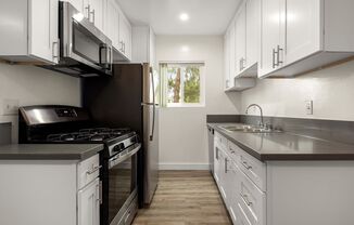 a kitchen with white cabinets and stainless steel appliances