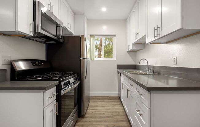 a kitchen with white cabinets and stainless steel appliances