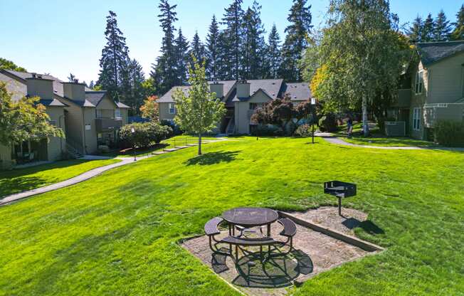 a backyard with a picnic table and a fire pit