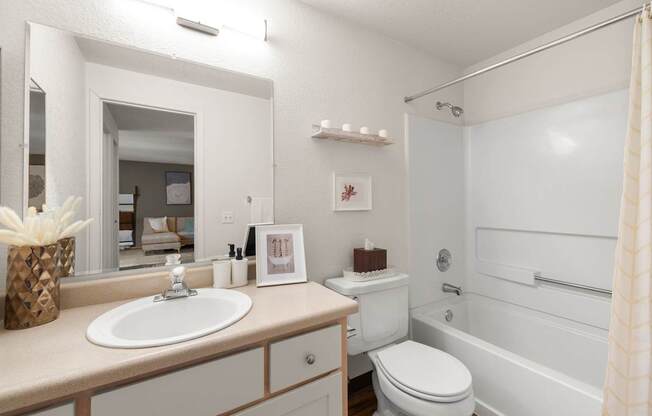 A white bathroom with a sink, toilet, and bathtub at Clackamas Trails Apartments, Oregon, 97222