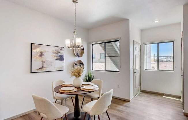 A dining room with a table set for four.