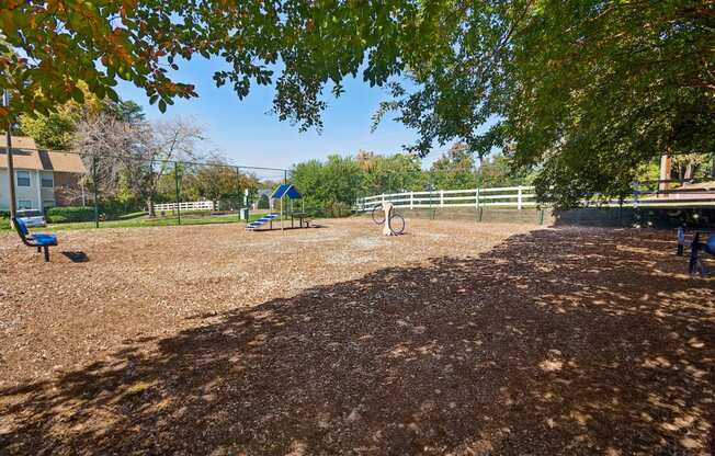 a playground with a swing set and a picnic table in a park