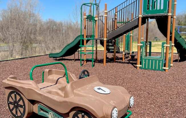 A brown toy car is on a playground.