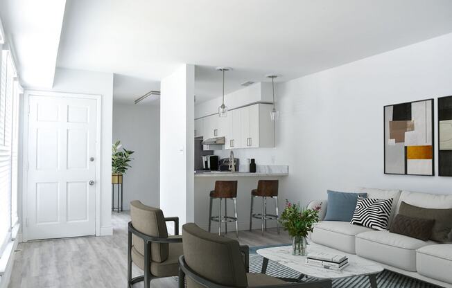 a living room with white walls and a white couch with a coffee table in front of it