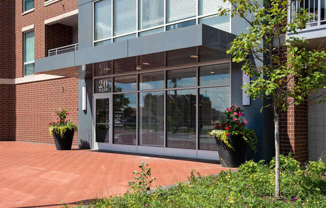 A building with a glass door and windows with a tree in front.