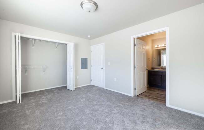 A room with a grey carpet and a white door.
