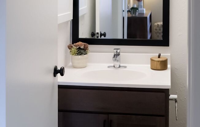 single bathroom vanity under a wall mirror