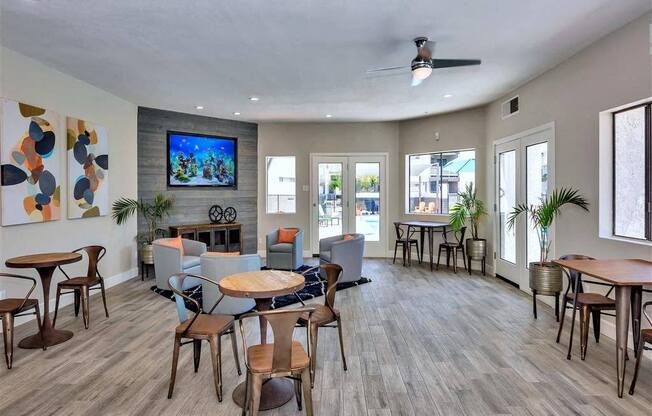 a living room with tables and chairs and a tv