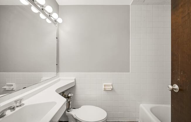a white bathroom with a white toilet and a sink