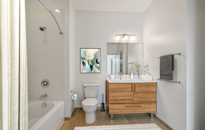 a bathroom with a toilet sink and shower and a mirror at The Merc, Waltham, MA