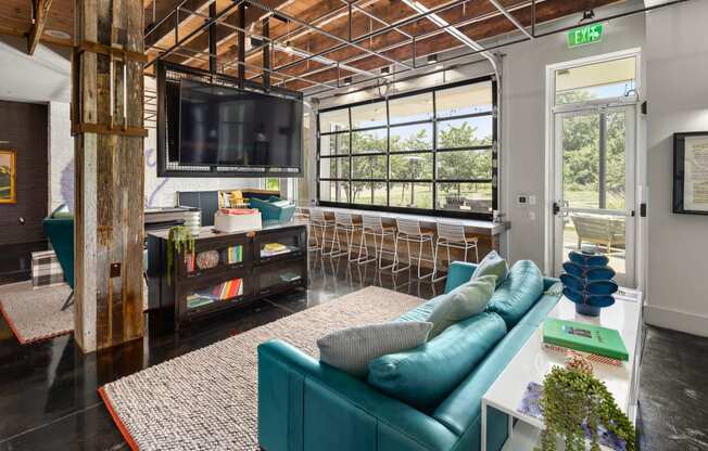 a living room filled with furniture and a large window  at Abberly Noda Vista Apartment Homes, Charlotte