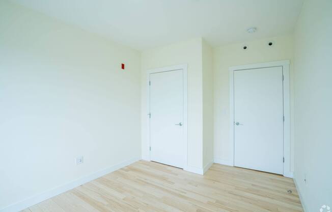 A room with two white doors and a wooden floor. at 603 Concord Apartments, Cambridge, Massachusetts