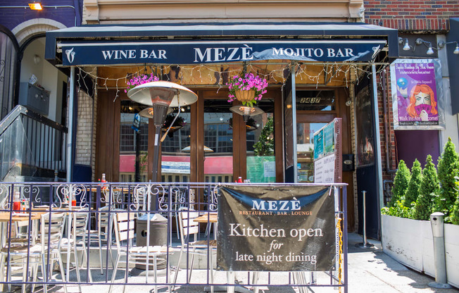 A sign in front of a restaurant advertises that the kitchen is open for late night dining.